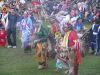 Variety of pow wow outfits in this picture, from Men's Traditional, to Fancy Shawl, to Jingle Dress, and even a young Grass Dancer.