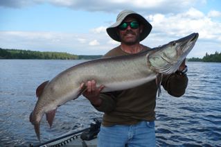 A proud fisherman shows off his nice muskie. Wouldn't you want to catch one too?